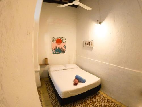 a small bed in a room with a ceiling fan at Hostal Españolete in Santa Marta