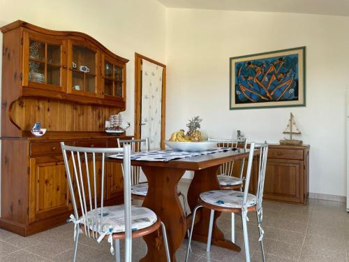 Oro Tramonto في توري دي كورساري: مطبخ مع طاولة وكراسي خشبية