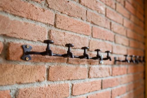 a row of water faucets on a brick wall at JEZ&SPI Plánice in Plánice