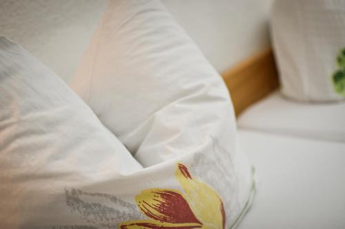 a pillow sitting on a bed with a white pillow at Gasthaus Alpenrose in Gramais