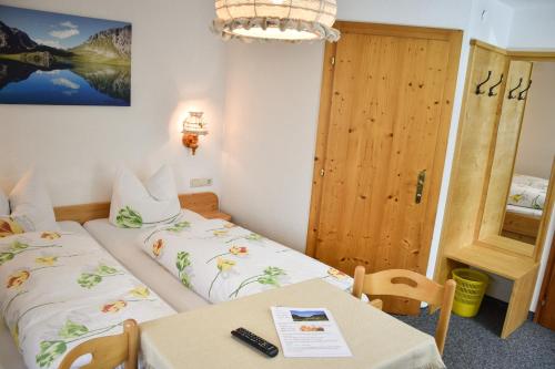 a small room with a bed and a table and a door at Gasthaus Alpenrose in Gramais