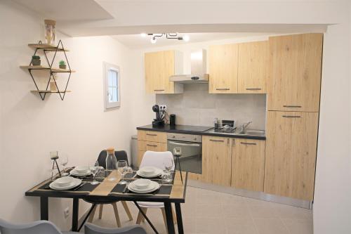 a kitchen with wooden cabinets and a table and chairs at #Cosy Moments By Eauz'Homes - WiFi-Netflix in Eauze