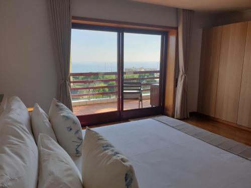 a bedroom with a large bed with a large window at Oporto Flag in Vila Nova de Gaia
