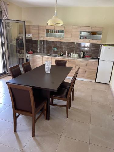eine Küche mit einem Tisch und Stühlen sowie einem Kühlschrank in der Unterkunft Villa Soula in Paralía Avdhíron