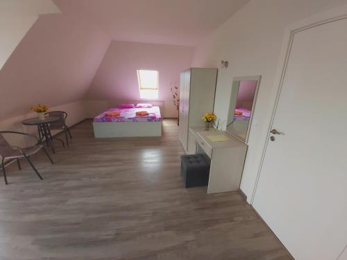 a room with a bed and a table and chairs at Bogdanovi Guest House in Chernomorets