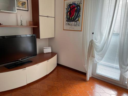 a living room with a flat screen tv and a window at Sweet Home in Trieste