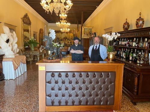 2 personnes debout à un bar dans une pièce dans l'établissement Hotel AB Baretta, à Legnaro
