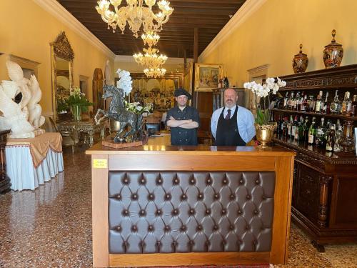 two people standing at a bar in a room at Hotel AB Baretta in Legnaro