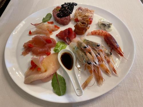 a plate of food with seafood on a table at Hotel AB Baretta in Legnaro