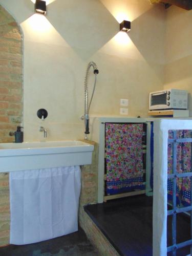 een badkamer met een wastafel en een magnetron aan de muur bij Montalcinello Casavolta WIFI, aria condizionata in Montingegnoli