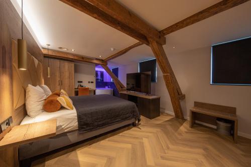 Schlafzimmer mit einem Bett und einem Flachbild-TV in der Unterkunft Boutique Hotel Scheepers in Valkenburg