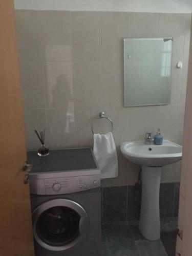 a bathroom with a washing machine and a sink at Davi's Studio Apartment in Paphos City