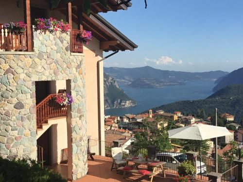 a house with a balcony with a view of a city at Home Iseo Lake in Bossico