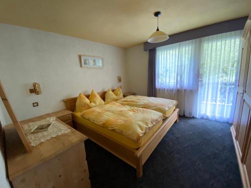 a bedroom with a bed and a large window at Chalet Alm in Zermatt