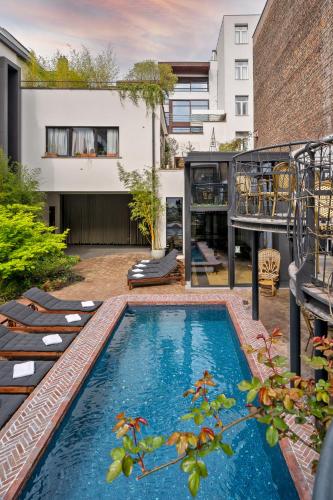 a backyard with a swimming pool and a house at Latroupe Hotel Le Berger in Brussels