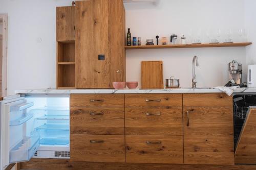 a kitchen with wooden cabinets and blue bins at Rarität Mein Herzenshaus im Altmühltal in Walting