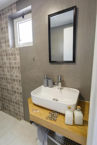 a bathroom with a sink and a mirror at Sole Mare Seaside Apartments in Gouves