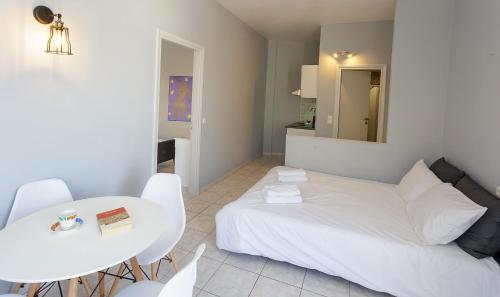 a bedroom with a white bed and a table and chairs at Sole Mare Seaside Apartments in Gouves