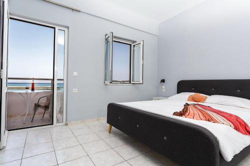a bedroom with a bed and a view of the ocean at Sole Mare Seaside Apartments in Gouves