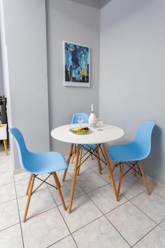 a table and two chairs with a white table and blue chairs at Sole Mare Seaside Apartments in Gouves