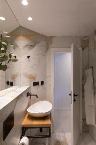 a bathroom with a white sink and a shower at Apartman Mali raj in Pakoštane