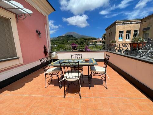 un patio con tavolo e sedie sul balcone. di Villa Aura a Torre del Greco
