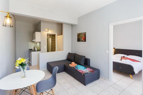 a living room with a couch and a bed and a table at Sole Mare Seaside Apartments in Gouves