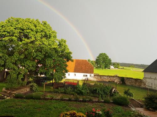 a rainbow over a garden with a house with a rainbow at Penzion Tvrz Dub u Tábora in Ratibořské Hory