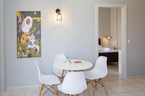 a white table and white chairs in a room at Sole Mare Seaside Apartments in Gouves