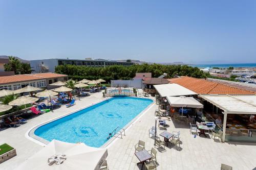an overhead view of a pool with umbrellas and chairs at Sole Mare Seaside Apartments in Gouves