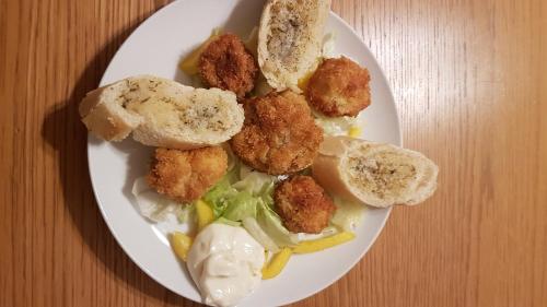 a plate of food with meatballs and bread on a table at Sycamore House in Laurière