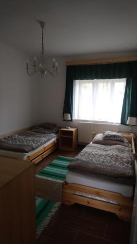 a bedroom with two twin beds and a window at SandorA Vendégház Nagyrákos in Nagyrákos