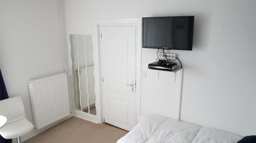 um quarto com uma televisão numa parede com uma cama em Sycamore House em Laurière