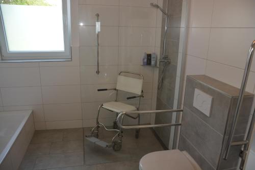 uma casa de banho com um WC e uma cadeira. em Vakantiehuiswinterberg em Winterberg