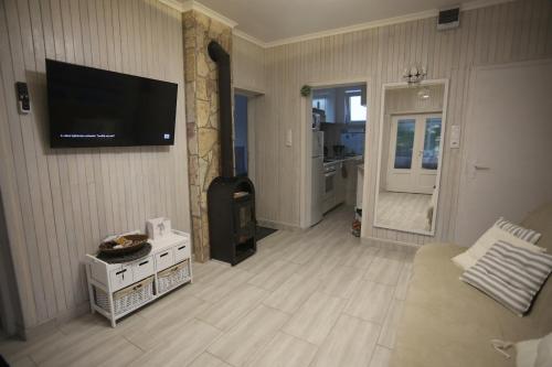 uma sala de estar com uma televisão de ecrã plano na parede em Lakilak pihenőház a Holt-Tisza partján, termálfürdőnél, Lakitelek em Lakitelek