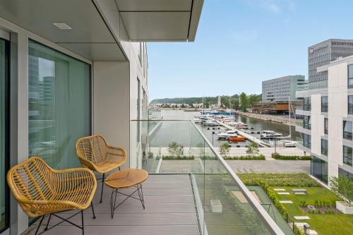 a balcony with two chairs and a view of a harbor at Marina View - Yacht Park Premiere in Gdynia