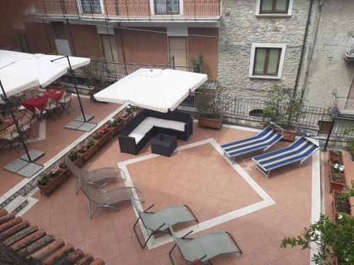an outdoor patio with chairs and tables and umbrellas at ANTICO FRANTOIO in Piaggine