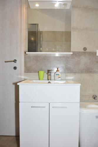 a bathroom with a white sink and a mirror at Apartman 2 in Senj