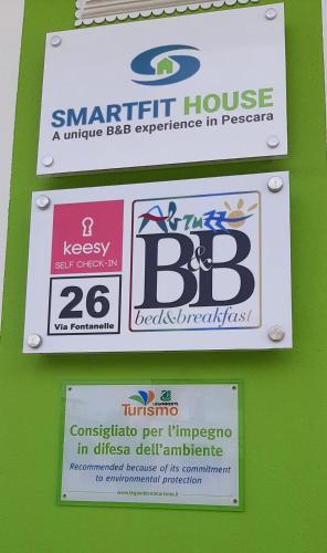two signs on the side of a green wall at B&B SMARTFIT HOUSE - Room & Relax in Pescara in Pescara