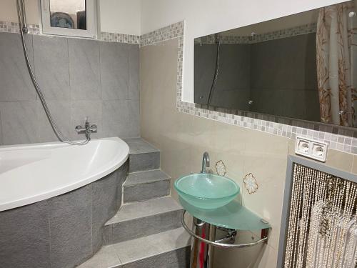 uma casa de banho com um lavatório e uma banheira em Apartments Let Me In em Pörtschach am Wörthersee
