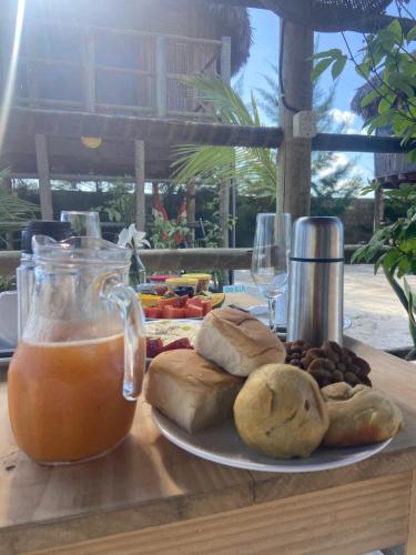 uma mesa com um prato de comida e uma bebida em Cabanadu Preá Kite em Praia do Preá