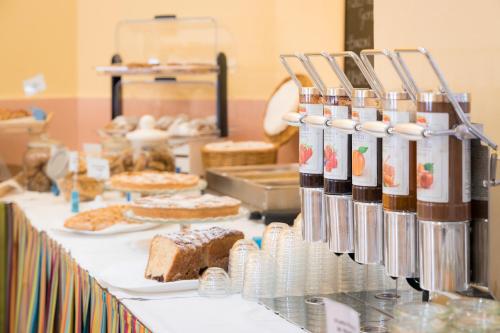 a buffet line with cakes and other food items at Viva Beach Hotel - 20m from the Beach & Large Breakfast in Rimini