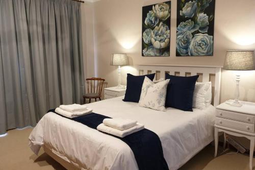 a bedroom with a large bed with towels on it at Coral Tree House in Graaff-Reinet