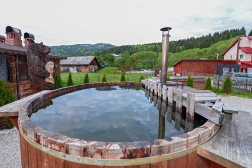 a wooden barrel pool with a wooden bench around it at Casa Teo&Andreea in Vatra Dornei