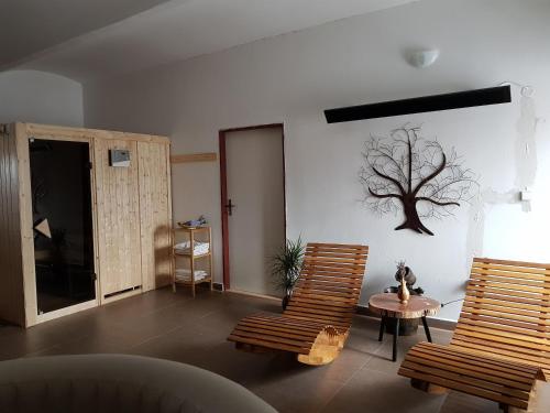a living room with two chairs and a tree on the wall at Penzion Tvrz Dub u Tábora in Ratibořské Hory