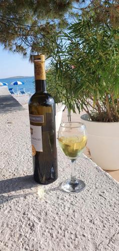 una botella de vino y una copa en una mesa en Medulin Luxury Apartments with beautiful garden 100 m from beach en Medulin