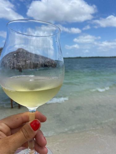 a person holding a glass of wine at the beach at Cabanadu Preá Kite in Prea