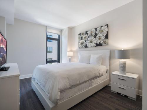 a white bedroom with a large bed and a window at Global Luxury Suites at Bethesda Metro in Bethesda