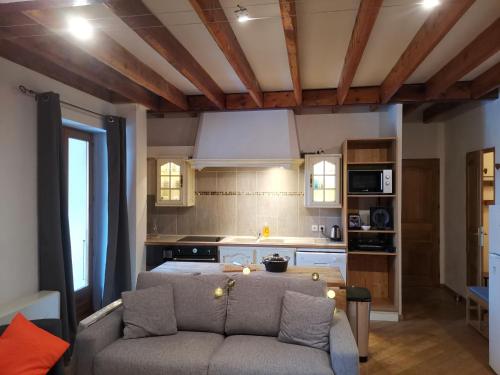 a living room with a couch and a kitchen at Residence le Cairn in Le Monêtier-les-Bains