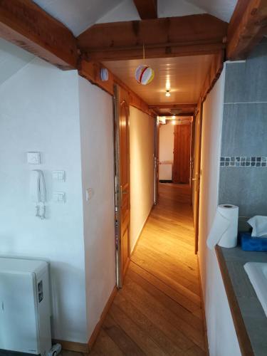 un couloir menant à une chambre avec salle de bains. dans l'établissement Residence le Cairn, au Monêtier-les-Bains